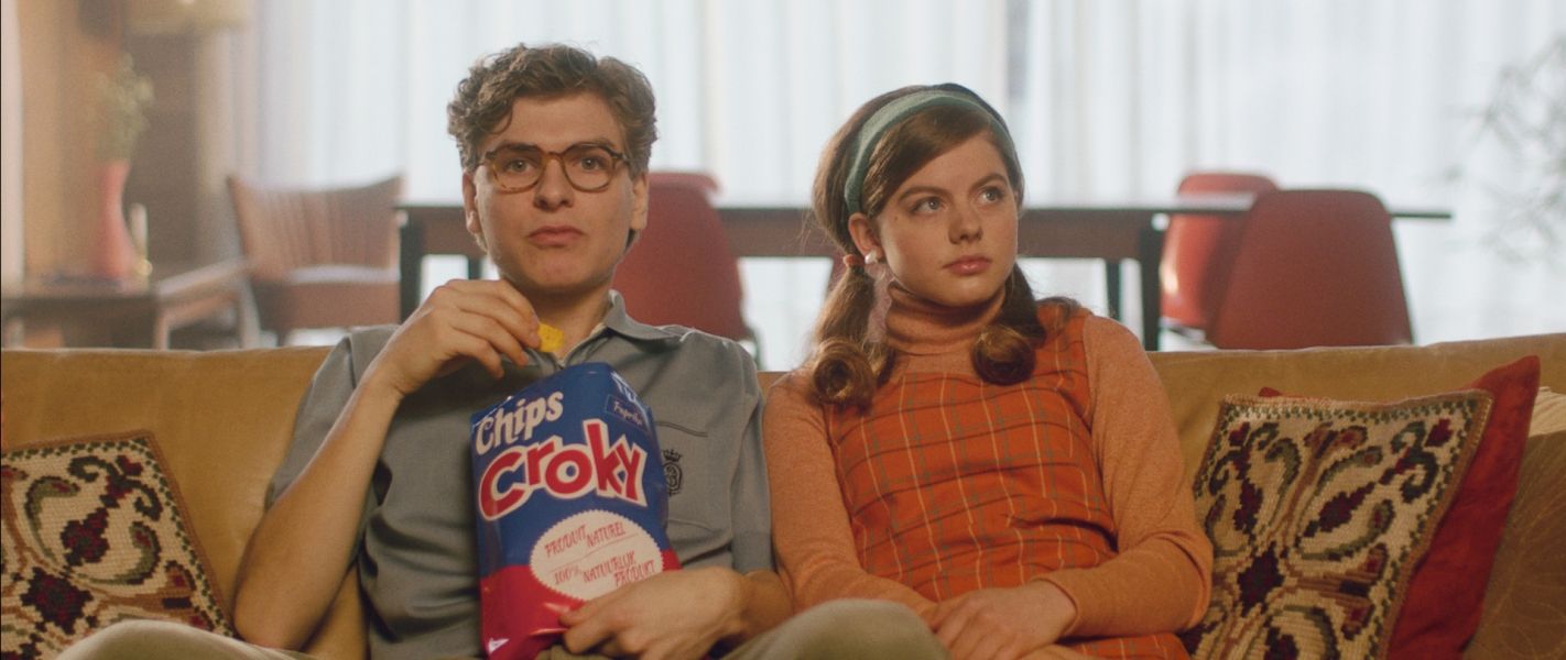 Couple jeune dans le canapé avec chips de Croky
